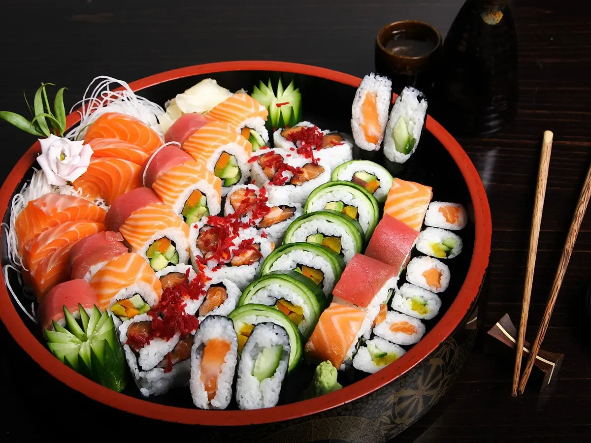 Osaka-Sushi-Japanese-Restaurant-Deluxe-Sushi-Platter-Redding Deluxe Sushi Platter presents a large assortment of sushi rolls and nigiri sushi, neatly arranged in a round bowl - shaped platter, with fresh ingredients such as salmon, tuna, cucumber, and colorful fillings, garnished with decorative elements like radish flowers at Osaka Sushi,a Japanese Restaurant in Redding