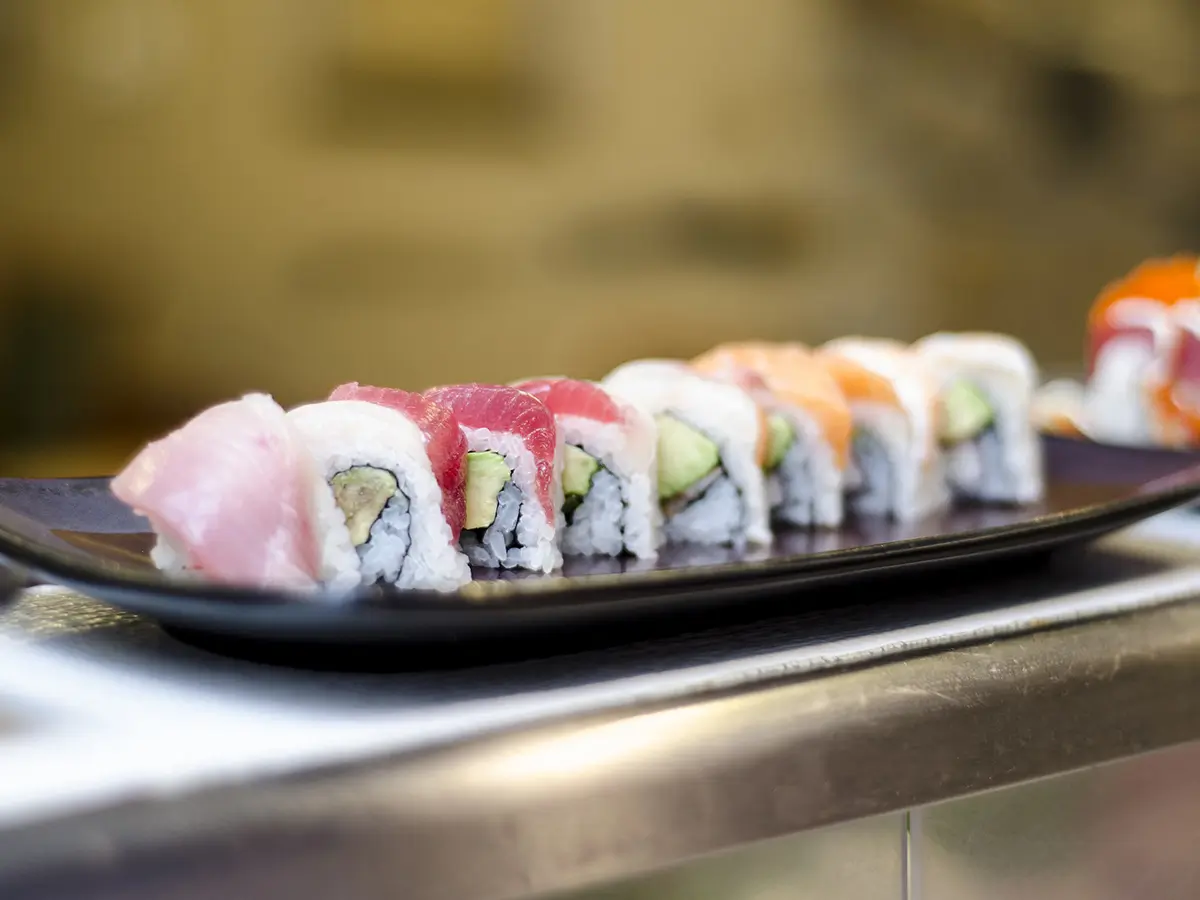 Sushi roll filled with crab salad, avocado, and topped with assorted sashimi slices for a rainbow effect at Osaka Sushi，a Japanese Restaurant in Redding